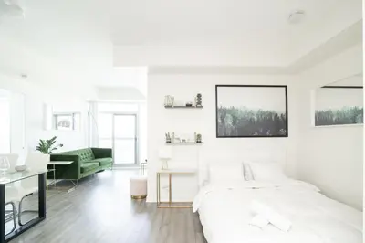 a white bedroom with a bed and a desk at Beautiful Luxurious Modern Condo With Breathtaking Views in Toronto