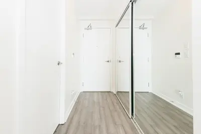 a mirror in a room with white walls and a wooden floor at Beautiful Luxurious Modern Condo With Breathtaking Views in Toronto