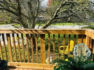 a wooden fence with a chair on a deck at Tiny House Haven in Peterborough