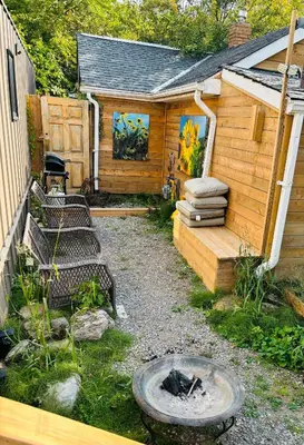 a backyard with a wooden cabin with a fire pit at Tiny House Haven in Peterborough
