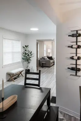 a living room with a table and a wine rack at The Little White Haus in Niagara on the Lake