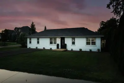 a white house with a dark roof at The Little White Haus in Niagara on the Lake