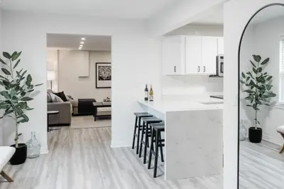 two views of a kitchen and a living room at The Little White Haus in Niagara on the Lake