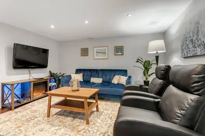 a living room with a couch and a tv at Lakeside Retreat near Toronto in Mississauga