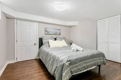 a bedroom with a bed with a blanket on it at Lakeside Retreat near Toronto in Mississauga