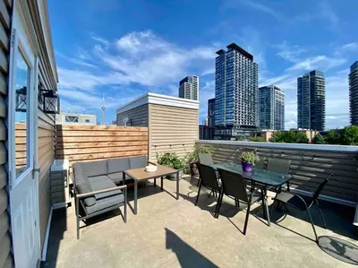 a patio with a table and chairs on a balcony at King West Private Rooftop Retreat in Toronto