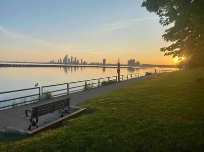 a park bench sitting next to a body of water at King West Private Rooftop Retreat in Toronto