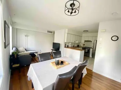 a living room with a table and chairs and a kitchen at King West Private Rooftop Retreat in Toronto