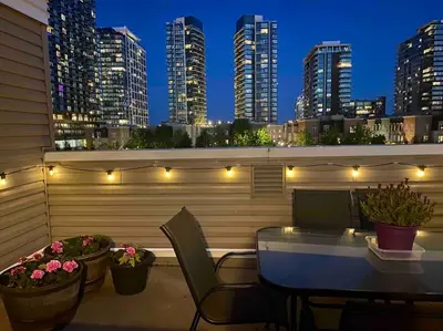 a rooftop patio with a table and chairs and lights at King West Private Rooftop Retreat in Toronto