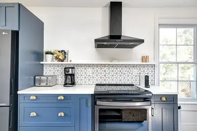 a kitchen with blue cabinets and a stove top oven at The Gem - Beautiful farmhouse with hot tub in West Lake