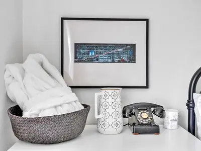 a basket of towels on a counter with a picture and a telephone at The Gem - Beautiful farmhouse with hot tub in West Lake