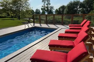 a row of red chairs next to a swimming pool at Away in the County-Sandbanks Pec in Cherry Valley