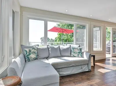a living room with a couch and a red umbrella at Wind & Waves - Wellington waterfront with Satellite TV & fire pit in Wellington