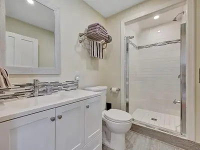 a white bathroom with a toilet and a shower at Wind & Waves - Wellington waterfront with Satellite TV & fire pit in Wellington