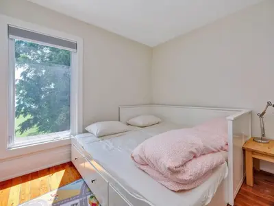 a white bedroom with a bed with a window at Wind & Waves - Wellington waterfront with Satellite TV & fire pit in Wellington
