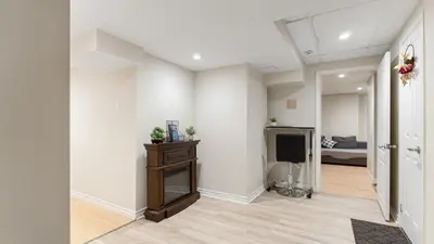 a living room with a television and a bedroom at Finished 2 BR Apartment in an Upscale Area of Ajax in Ajax