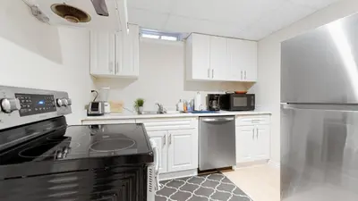 a kitchen with white cabinets and black appliances at Finished 2 BR Apartment in an Upscale Area of Ajax in Ajax