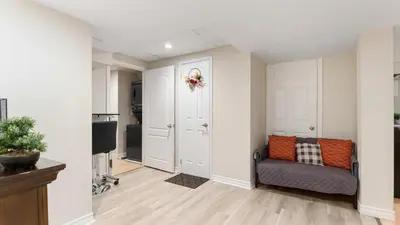 a living room with a couch and a door at Finished 2 BR Apartment in an Upscale Area of Ajax in Ajax