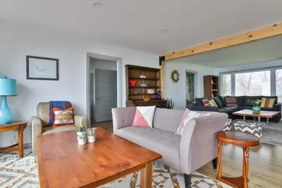 a living room with a couch and a table at Lakeside PEC: Beautiful Waterfront & Patio in Wellington