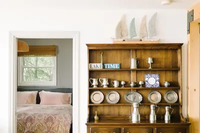 a bedroom with a book shelf with plates on it at Lakeside PEC: Beautiful Waterfront & Patio in Wellington