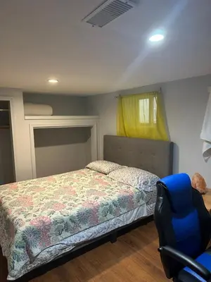 a bedroom with a bed and a blue chair at Angelina’s house in Toronto