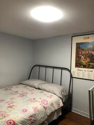 a bedroom with a bed and a painting on the wall at Angelina’s house in Toronto