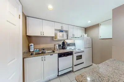 a kitchen with white cabinets and a sink and refrigerator at Condo 708 at North Creek Resort in Blue Mountains