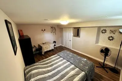 a bedroom with a bed and a table in it at Affordable stay near the OPG TV and parking in Pickering