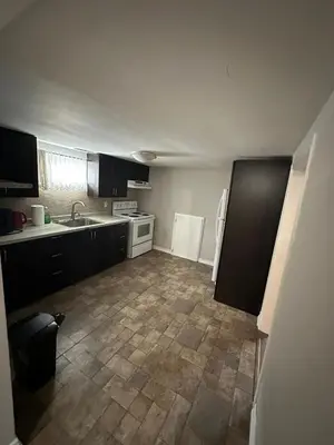 a large kitchen with a tile floor and a sink at Affordable stay near the OPG TV and parking in Pickering