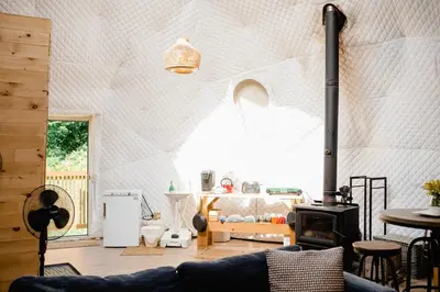 a living room with a couch and a wood stove at Open Sky Glamping Kawartha Dome in Marmora
