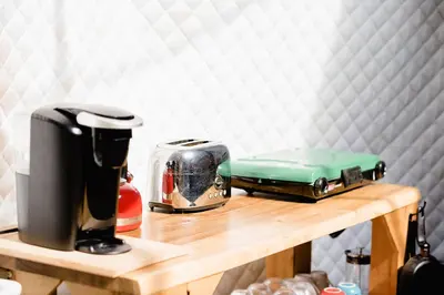 a table with a coffee maker and a toaster on it at Open Sky Glamping Kawartha Dome in Marmora