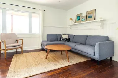 a living room with a blue couch and a table at Grays Lane - Minutes to Sandbanks in Bloomfield