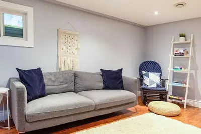 a living room with a gray couch and a chair at Grays Lane - Minutes to Sandbanks in Bloomfield
