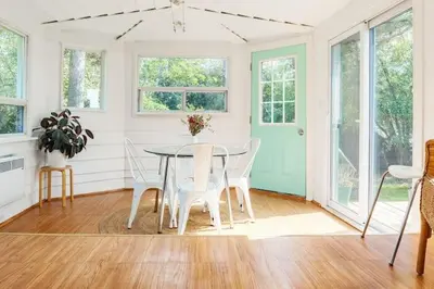 a dining room with a table and white chairs at Grays Lane - Minutes to Sandbanks in Bloomfield