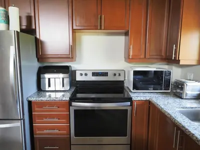a kitchen with wooden cabinets and a stove top oven at Gateside Chalets Expansive 6 Bedroom Hot Tub Near Village Blue Mountain in Blue Mountains