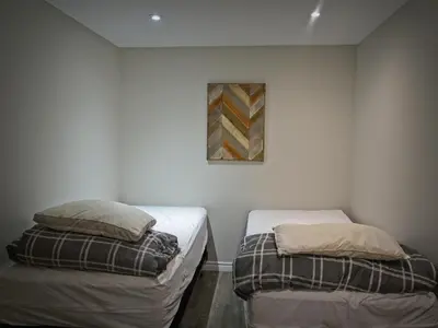 two beds in a room with a picture on the wall at Gateside Chalets Expansive 6 Bedroom Hot Tub Near Village Blue Mountain in Blue Mountains