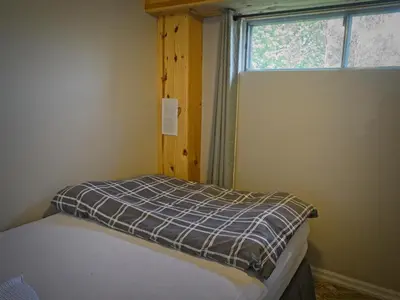 a small bedroom with a bed and a window at Gateside Chalets Expansive 6 Bedroom Hot Tub Near Village Blue Mountain in Blue Mountains