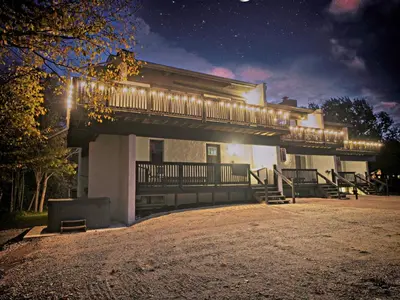 a building with a balcony with lights on it at Gateside Chalets Expansive 6 Bedroom Hot Tub Near Village Blue Mountain in Blue Mountains