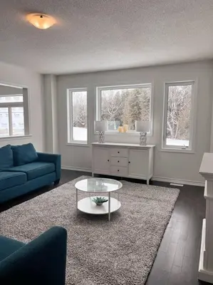 a living room with a blue couch and a coffee table at Modern & Cozy Kawartha Getaway in Kawartha Lakes