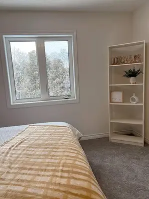 a bedroom with a bed and a window at Modern & Cozy Kawartha Getaway in Kawartha Lakes