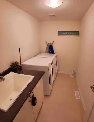 a laundry room with a washing machine and a sink at Modern & Cozy Kawartha Getaway in Kawartha Lakes