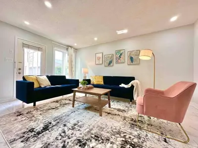 a living room with two blue couches and a table at Charming Home in Prime Location North of Toronto in Richmond Hill