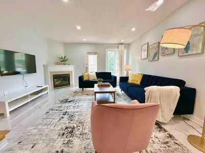 a living room with a blue couch and a fireplace at Charming Home in Prime Location North of Toronto in Richmond Hill