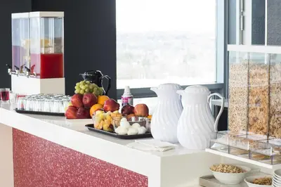 a counter with a plate of fruit and vases on it at Liberty Suites in Thornhill