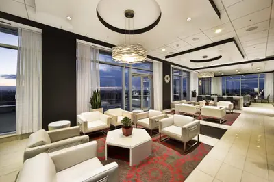 a waiting room with white chairs and tables and windows at Liberty Suites in Thornhill