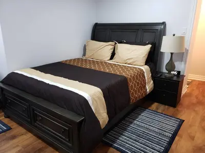 a bedroom with a large bed with a black headboard at Luxurious 1BR - 1BA Apt Modern Bright with free parking-pc in Brampton