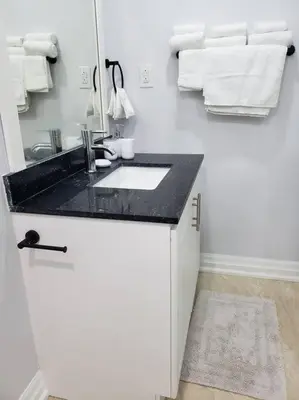 a white bathroom with a sink and a mirror at Luxurious 1BR - 1BA Apt Modern Bright with free parking-pc in Brampton