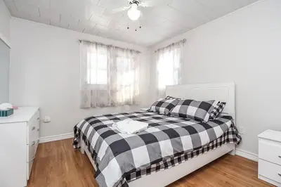 a white bedroom with a black and white bed at Farm House in Coldwater