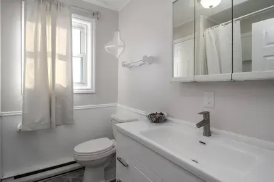 a white bathroom with a toilet and a sink at Farm House in Coldwater