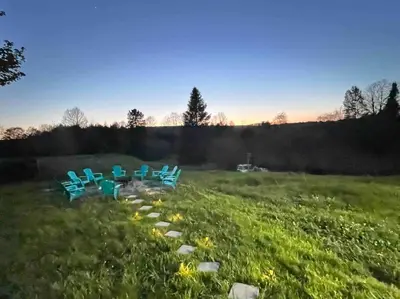 a group of blue chairs sitting in a field at Farm House in Coldwater